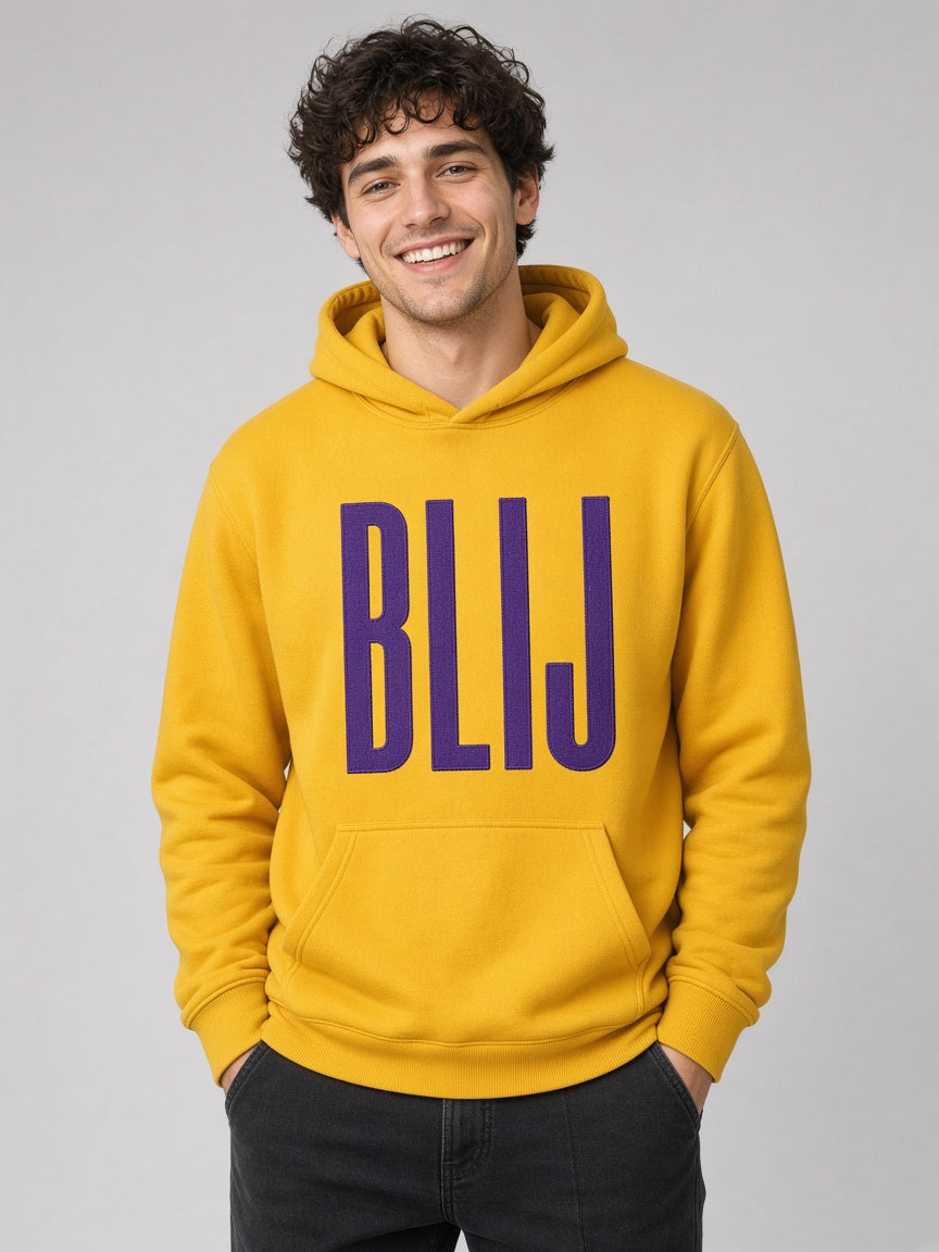 Man draagt de HUMEURIG BLIJ Hoodie in goud met paars borduursel (heren)