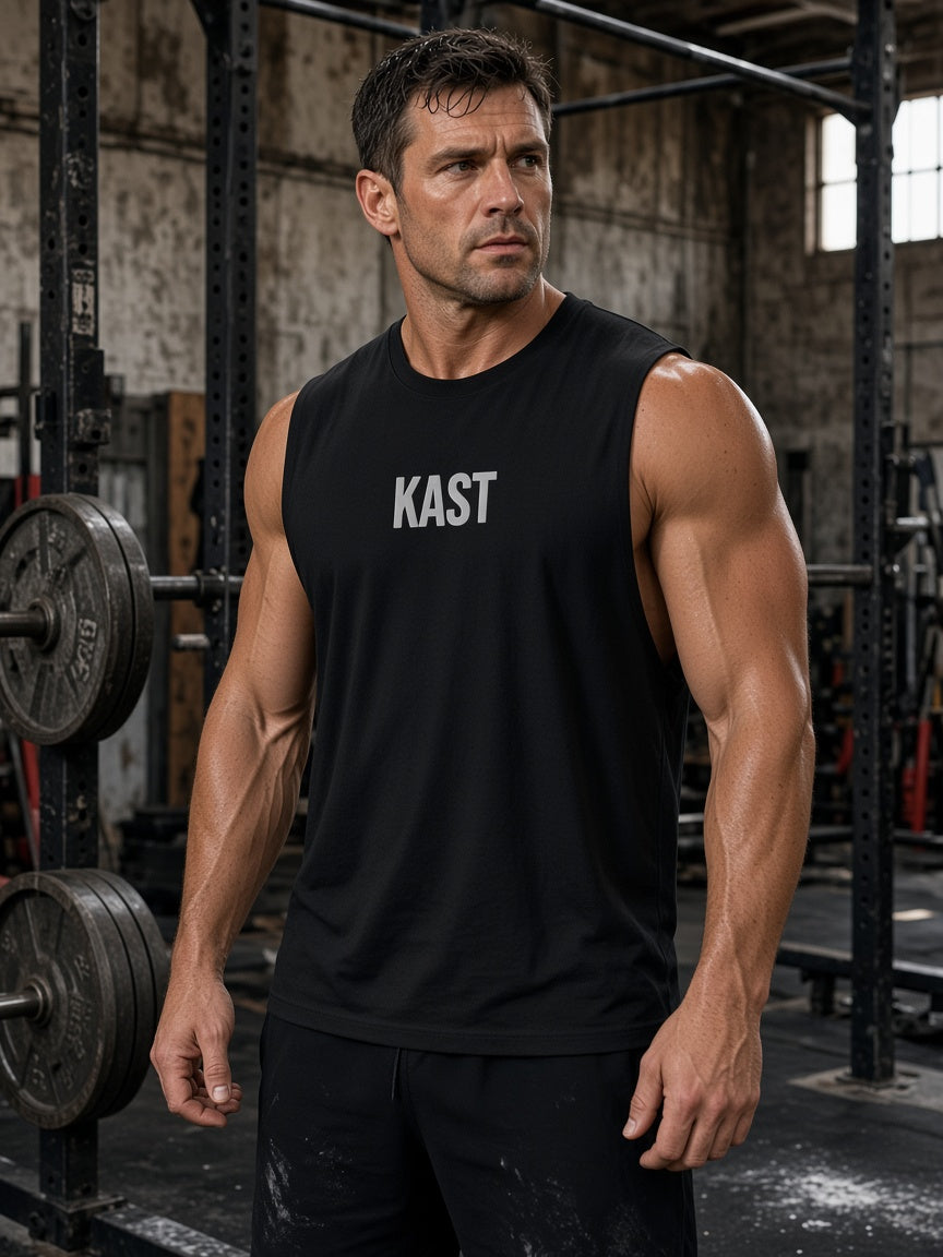 Model draagt de HUMEURIG KAST Muscle Shirt in Zwart/Wit met het woord KAST geborduurd