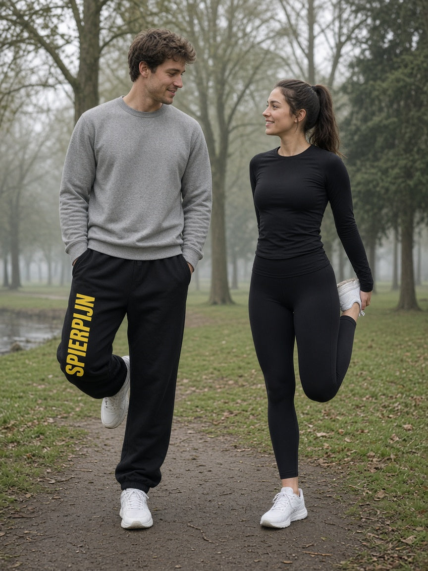 Model draagt de HUMEURIG SPIERPIJN Wijde jogger in zwart, volledig gekleed (heren)