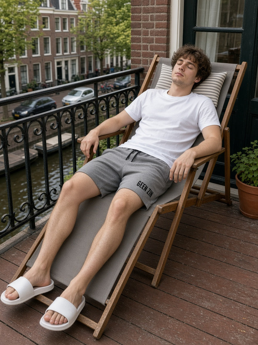 Model draagt de HUMEURIG GEEN ZIN Short in grijs met wit shirt (heren)
