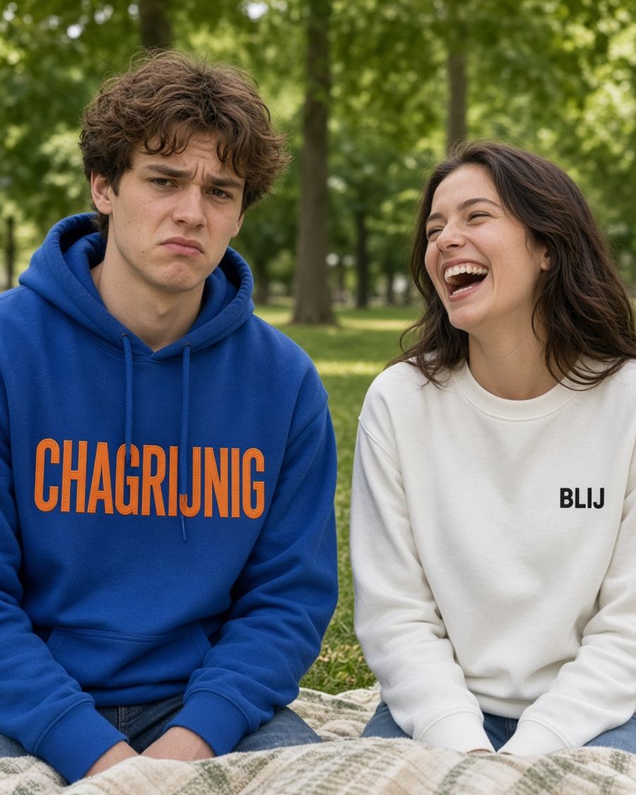Model draagt de HUMEURIG CHAGRIJNIG Hoodie in Royal/Oranje met het woord CHAGRIJNIG geborduurd (dames)